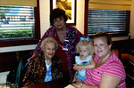 Three Women And a Child Pose For a Photograph