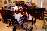 Children In Classroom Holding Up Books