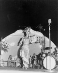 Drag queen performing in front of a band