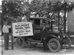 Automobile, men, and a sign advertising the official car of the Florida Grower for the Tamiami Trail exploration by Burgert Brothers