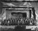 Group portrait on the stage of the auditorium at Centro Asturiano de Tampa by Burgert Brothers