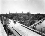 Horse-drawn carriages crossing the Lafayette Street Bridge in front of the Tampa Bay Hotel by Burgert Brothers