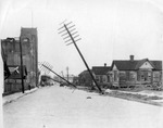 Toppled utility poles line a brick road in Ybor City after the hurricane of 1921 by Burgert Brothers