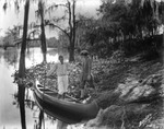 A couple prepares to launch a canoe on the Hillsborough River by Burgert Brothers