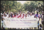 Group of people from ETA RHO Chapter of the Omega PSI PHI Fraternity, Inc. holding a sign with group name.