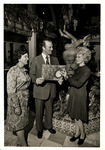 Cesar Gonzmart Posing with Ladies and a Columbia Restaurant Menu in the Patio Room by Unknown