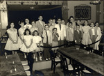 Children Gather on the Stage of the Siboney Room, with Richard (Plaid Shorts) and Casey Gonzmart (White Coat) in the Center by Unknown