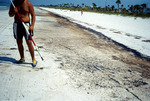 Man standing on an oil-polluted beach in Pinellas County, Florida