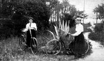 Two women stand with their bicycles
