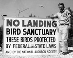 Ed Rowell poses next to a National Audubon Society sign by Allan D. Cruickshank
