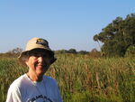 Peggy Powell smiles against a backdrop of tall grass and palm trees in Leesburg by Florida Ornithological Society