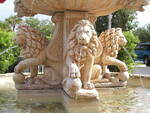 Water flows from the mouth of a lion statue on a Mount Dora fountain