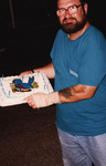 Wes Biggs holds up a 700th bird cake at Archbold Biological Station by Florida Ornithological Society