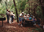 Florida Ornithological Society (FOS) members with binoculars observe within the wilderness at Spanish River Park in Boca Raton by Florida Ornithological Society
