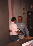 Glen Woolfenden and Fred Lohrer embrace behind the podium at the Florida Ornithological Society (FOS) 1994 meeting in West Palm Beach
