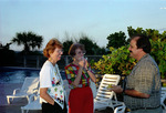 Three Florida Ornithological Society (FOS) members smile and chat by the pool during the 1995 fall meeting in Cocoa Beach