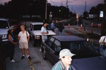 Small groups of Florida Ornithological Society members stand chatting beside their cars on Ocean Street in Jacksonville, Florida