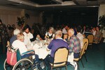 Seven adults and two children gather around a dinner table in a large banquet room during a Florida Ornithological Society meeting in Jacksonville, Florida