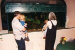 Two adults hold up two small children so they can observe a fish tank during a Florida Ornithological Society meeting in Jacksonville, Florida
