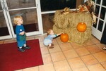 Two small children admire and approach a fall setup with two pumpkins during a Florida Ornithological Society meeting in Jacksonville, Florida