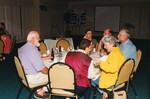 John Douglas sits at a round dinner table with five other Florida Ornithological Society members at a meeting in Jacksonville, Florida