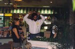A man holds a small toddler on his shoulders while talking with two other Florida Ornithological Society members at a meeting in Jacksonville, Florida