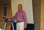 John Fitzpatrick presents in front of a projector screen at a Florida Ornithological Society meeting in Tampa, Florida