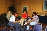 Three people chat in a small group during a Florida Ornithological Society meeting in Tampa, Florida