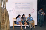 Three guests sit and chat on a bench at the Florida Museum of Natural History