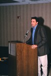 A speaker in a suit and button-up gives a presentation at a Florida Ornithological Society meeting in Gainesville, Florida