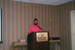 A speaker in a pink polo gives a presentation at a Florida Ornithological Society meeting in Gainesville, Florida by Florida Ornithological Society