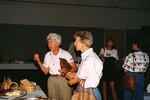 Peggy Powell and Mary Davidson speak to someone over the food table at a Florida Ornithological Society meeting in Gainesville, Florida