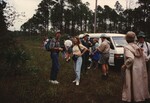 Florida Ornithological Society members cluster beside a van on a dirt road during a birding trip in the Bahamas