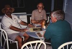 Fred Lohrer and two other Florida Ornithological Society members chat at a restaurant in the Bahamas by Florida Ornithological Society