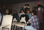 A man kneels talking to three seated Florida Ornithological Society members at a fall meeting in the Bahamas by Florida Ornithological Society