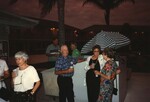 Groups of Florida Ornithological Society members mingle on a poolside deck by the bar during the 1996 meeting in the Bahamas by Florida Ornithological Society