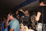 Two Florida Ornithological Society members chat and gesture with drinks in hand during the 1996 meeting in the Bahamas