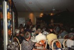 A room of seated audience members pays attention to a presenter in a patterned shirt at the Florida Ornithological Society 1996 fall meeting by Florida Ornithological Society