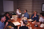 Guests line a conference table and mingle amongst themselves during a Florida Ornithological Society meeting in Tallahassee, Florida by Florida Ornithological Society