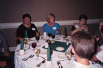 Guests laugh and converse around a dinner table during a Florida Ornithological Society meeting in Tallahassee, Florida
