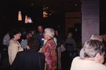 A group of Florida Ornithological Society members stands by a bar with TVs overhead in Tallahassee, Florida