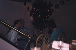 Guests chat at a corner table beside a lit-up tree in Titusville, Florida