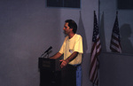 Jim Cox stands at a podium in a yellow shirt during a Florida Ornithological Society meeting in Titusville, Florida
