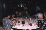 Guests chat around a dinner table during a Florida Ornithological Society meeting in Titusville, Florida