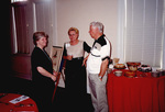 Three guests mingle by a dessert table at a Florida Ornithological Society meeting in Fort Pierce, Florida by Florida Ornithological Society