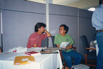 Dean Jue chats with a colleague over a stack of papers at a Florida Ornithological Society meeting in Fort Pierce, Florida by Florida Ornithological Society