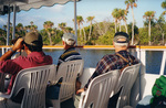 Three tourists view the shoreline during a boat tour in Fort Pierce, Florida