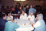 Flip Harrington, Maryanne Thomas, and other guests mingle amongst themselves in a large banquet hall in Fort Pierce, Florida