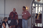 Ann Paul looks on as John Douglas and Jim Cox speak in Fort Pierce, Florida