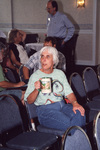 Sally Jue sits with a decorated travel mug during a Florida Ornithological Society meeting in Fort Pierce, Florida